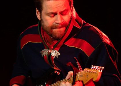 bilde av gitarspillende mann i samekofte